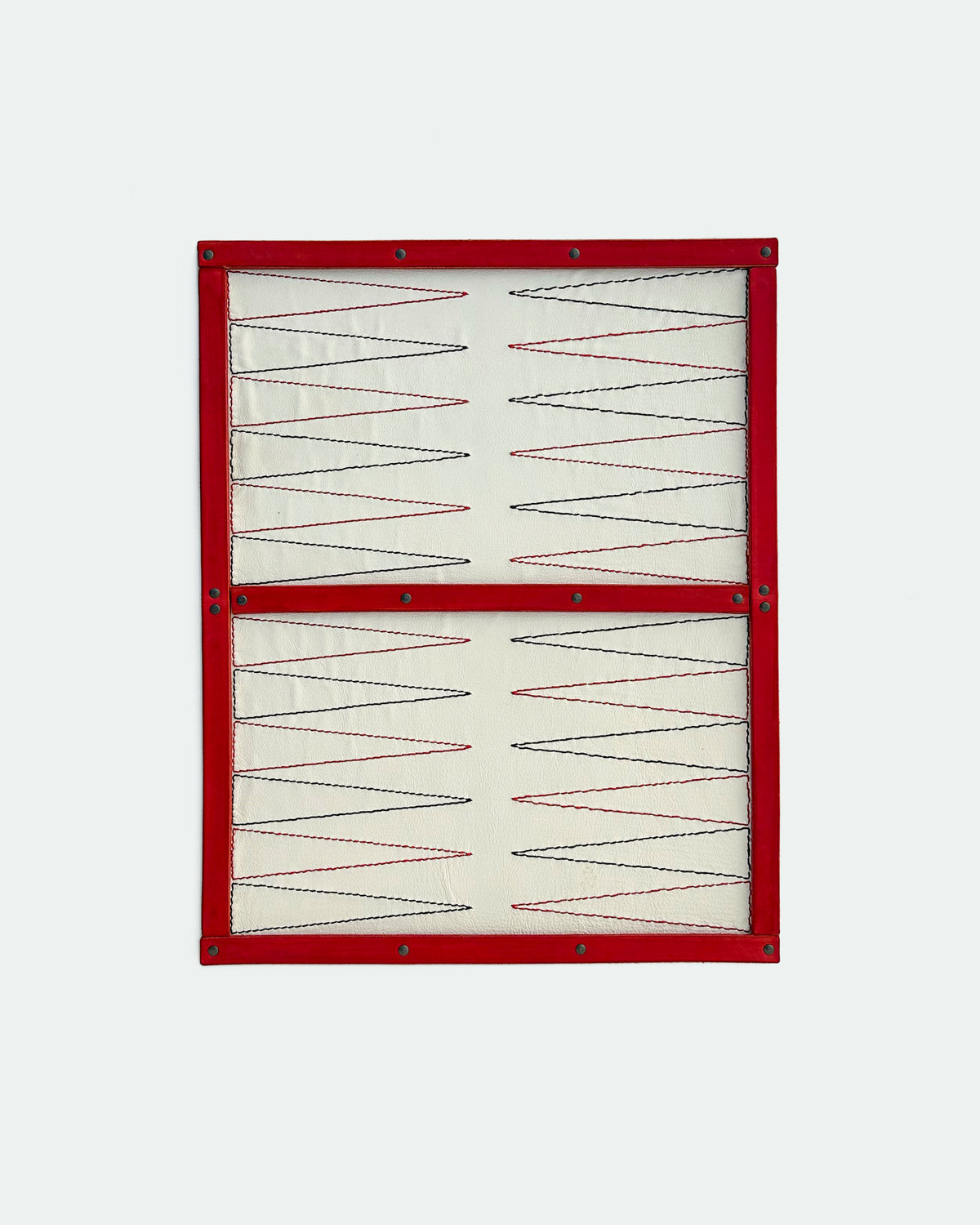 The Drifter 26, a leather backgammon board. White leather with black and red points.