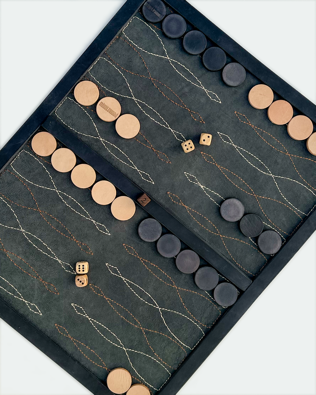 Black saddle stitch backgammon board with leather players and dice